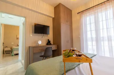 a bedroom with a bed and a desk and a television at Grande Terra in Kiotari