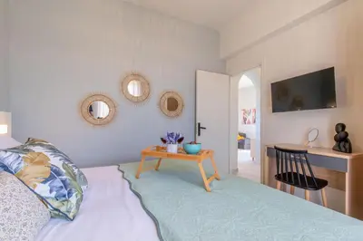 a bedroom with a bed with a table and mirrors at Grande Terra in Kiotari