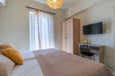 a bedroom with a bed and a desk and a television at Grande Terra in Kiotari