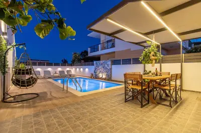 a patio with a pool and a table and chairs at Grande Terra in Kiotari