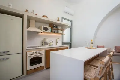a kitchen with a white counter and a white refrigerator at Athoros Luxury Villas in Afantou