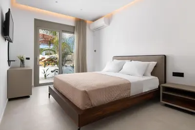 a bedroom with a large bed and a window at Golf Beach Villa in Afantou