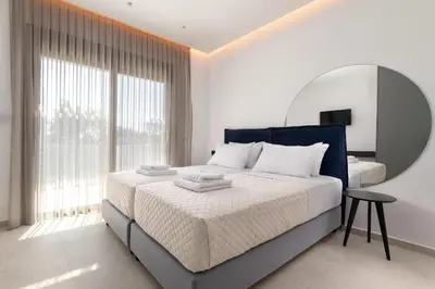 a bedroom with a large bed and a mirror at Golf Beach Villa in Afantou