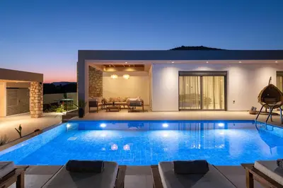 a swimming pool in a villa at night at Golf Beach Villa in Afantou