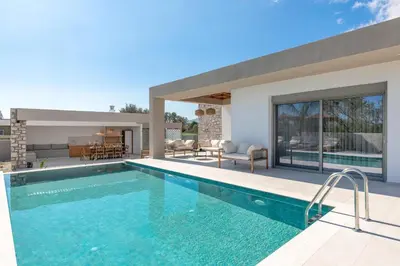 a swimming pool in a villa with a house at Golf Beach Villa in Afantou