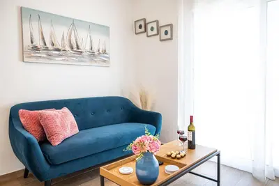 a blue couch in a living room with a table at Rhodes Sunset House in Rhodes Town
