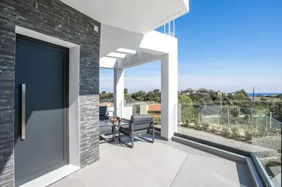 a patio with a sliding glass door with a table and chairs at Villa Seranti in Asgourou