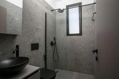 a bathroom with a glass shower with a sink at Villa Seranti in Asgourou