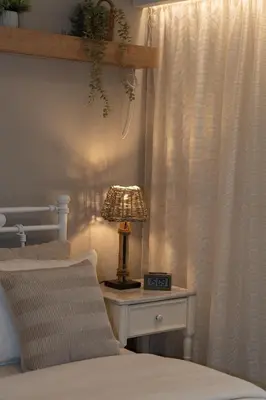 a bed with a lamp on a table next to a window at Ixia home in Ixia