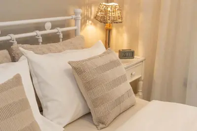 a bedroom with a bed with white pillows and a lamp at Ixia home in Ixia