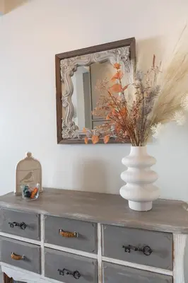 a mirror on top of a dresser with a vase at Ixia home in Ixia