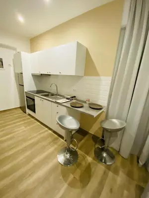 a kitchen with a sink and two stools in it at Block66 in Rhodes Town