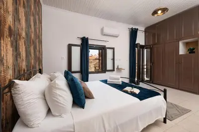 a bedroom with a bed with white and blue pillows at Emerald Dream House, Aithria in Rhodes Town