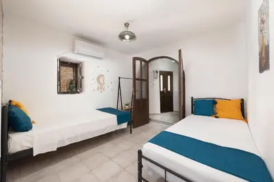 two beds in a room with white walls at Emerald Dream House, Aithria in Rhodes Town