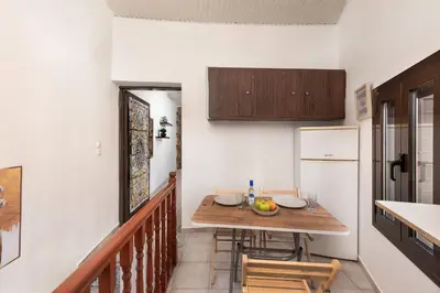 a small kitchen with a wooden table and a refrigerator at Emerald Dream House, Aithria in Rhodes Town