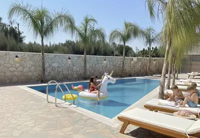a group of people riding on an unicorn in a swimming pool at Odyssea Front Beach in Kremasti