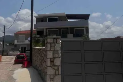 a house with a fence and a garage at Odyssea Front Beach in Kremasti