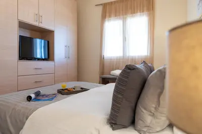 a hotel room with a bed with a television and a bed sidx sidx at Gennadi Beach Front in Gennadi