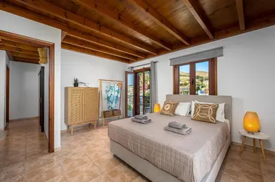 a bedroom with a bed in a room with windows at Symiland Villa in Symi