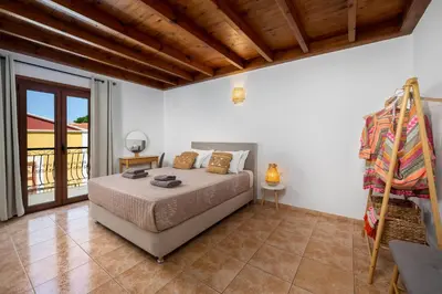 a bedroom with a bed and a balcony at Symiland Villa in Symi