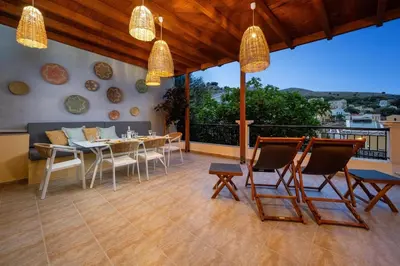 a patio with a table and chairs on a balcony at Symiland Villa in Symi