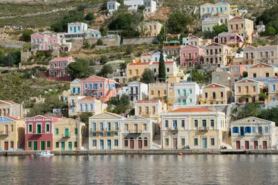 a group of houses on a hill next to the water at Symiland Villa in Symi