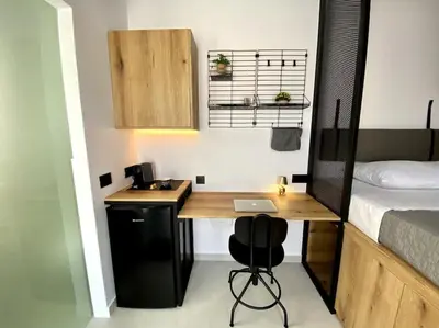 a small room with a desk and a bed at TinyVibe - Downtown Seabreeze Studio in Rhodes Town