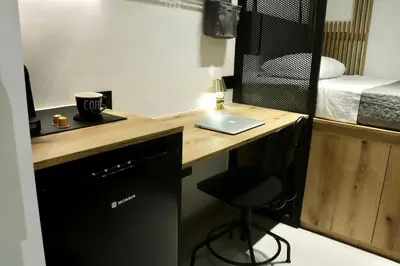 a desk with a laptop and a chair in a room at TinyVibe - Downtown Seabreeze Studio in Rhodes Town