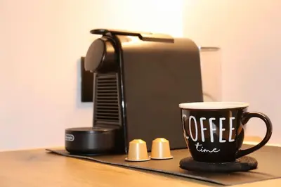 a coffee cup sitting next to a coffee maker at TinyVibe - Downtown Seabreeze Studio in Rhodes Town