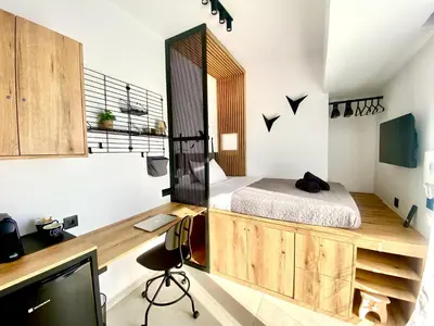 a bedroom with a bed and a desk with a tv at TinyVibe - Downtown Seabreeze Studio in Rhodes Town