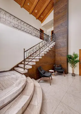 a bedroom with a staircase and two chairs at Greenheart - Mediterranean Elegance in Nature in Ialyssos