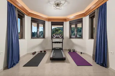 a room with a gym with yoga mats and windows at Greenheart - Mediterranean Elegance in Nature in Ialyssos