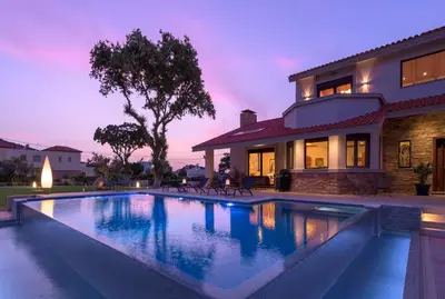 a swimming pool in front of a house at Greenheart - Mediterranean Elegance in Nature in Ialyssos
