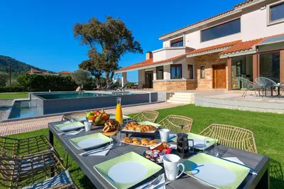 a table with food on it in front of a house at Greenheart - Mediterranean Elegance in Nature in Ialyssos