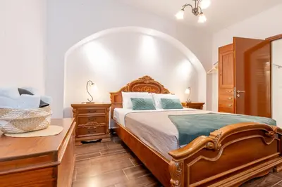 a bedroom with a large bed and a wooden table at Mascot Memories in Rhodes Town
