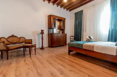 a bedroom with a bed and a chair and a window at Mascot Memories in Rhodes Town