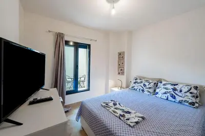 a bedroom with a bed and a desk with a computer monitor at Rhodes Center Apartment in Rhodes Town