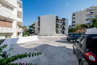 a parking lot with cars parked in front of buildings at Rhodes Center Apartment in Rhodes Town