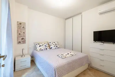 a white bedroom with a bed and a tv at Rhodes Center Apartment in Rhodes Town