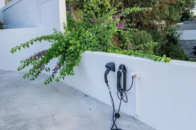 a black corded phone leaning against a white wall at Rhodes Center Apartment in Rhodes Town