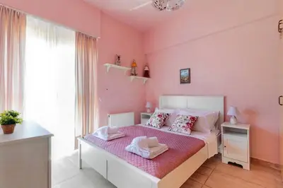 a pink bedroom with a bed with a pink wall at Ivi CentralApartment Rhodes Town in Rhodes Town
