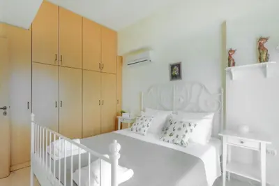 a white bedroom with a white bed and cabinets at Ivi CentralApartment Rhodes Town in Rhodes Town