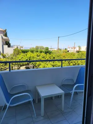 a pair of chairs and a table on a balcony at Pyrgos Hotel Apartments in Kremasti