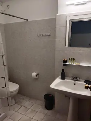 a bathroom with a sink and a toilet and a mirror at Pyrgos Hotel Apartments in Kremasti