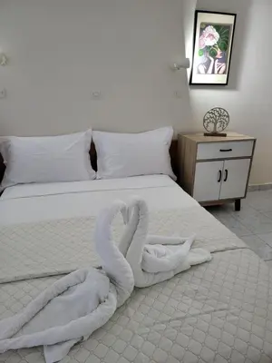 a bed with two swans made out of towels at Pyrgos Hotel Apartments in Kremasti