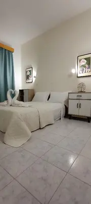 a bedroom with two beds and a dresser at Pyrgos Hotel Apartments in Kremasti
