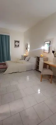 a large bedroom with two beds and a table at Pyrgos Hotel Apartments in Kremasti