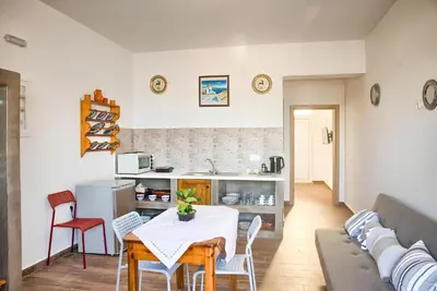 a living room with a table and chairs and a couch at La mer stegna in Archangelos