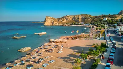 an aerial view of a beach with umbrellas and people at La mer stegna in Archangelos
