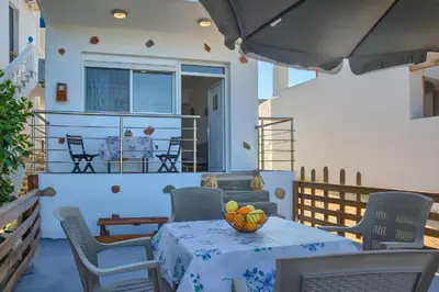 a table with a bowl of fruit on a patio at La mer stegna in Archangelos